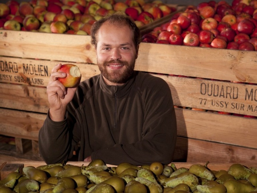 Un artisan pose avec des fruits